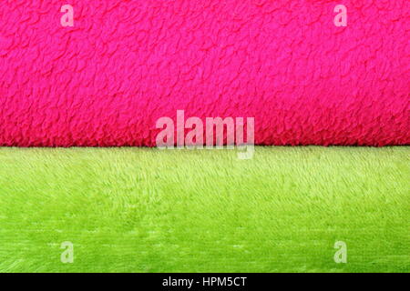 colorful background of textured blankets, detail of stack with green and pink material Stock Photo