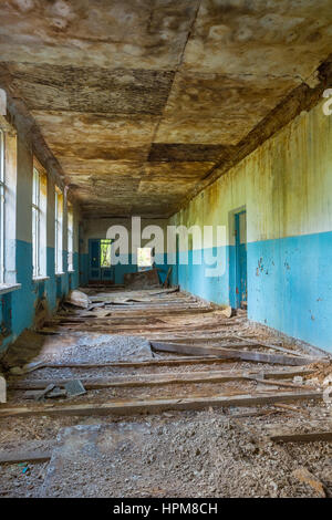 The Ruined Long Corridor Of Abandoned School After Chernobyl Disaster In Evacuation Zone. Consequences Of The Nuclear Pollution Twenty Years Later. Stock Photo