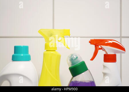 various cleaning products and detergent in front of white bathroom tiles with copy space Stock Photo