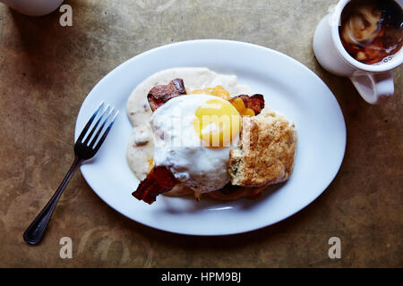 Southern Decadence - Buttermilk biscuit, chicken fried chicken, bacon, cheddar, country sausage gravy, sunny side up egg $13.95 Stock Photo