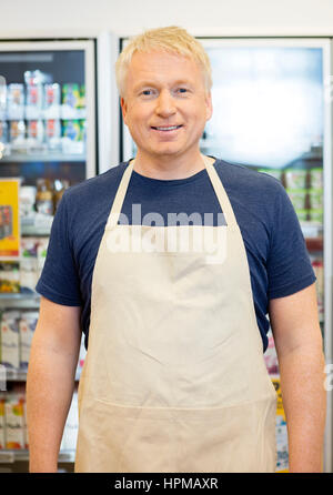 Portrait of confident mature salesman smiling in grocery store Stock Photo