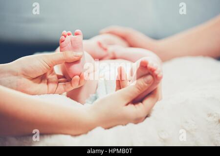 Touch of the parent love. Couple caress their little baby in the bed. Stock Photo