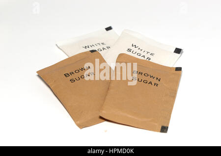 Small paper package of white and brown sugars on isolated white background. Stock Photo