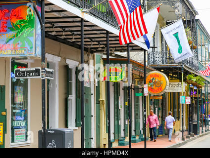 New Orleans, USA - May 14, 2015: Junction of Bourbon Street and Orleans Street in French Quarter. There are many neon signs and flags at the buildings Stock Photo