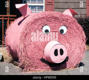 In Landrum, SC, a whimsical pink hay bale pig adds a touch of farmyard fun and creativity to the roadside, delighting passersby with its charm. Stock Photo