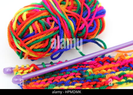 Bright multi-coloured colorful knitting wool or yarn with knitting needles on white background Stock Photo
