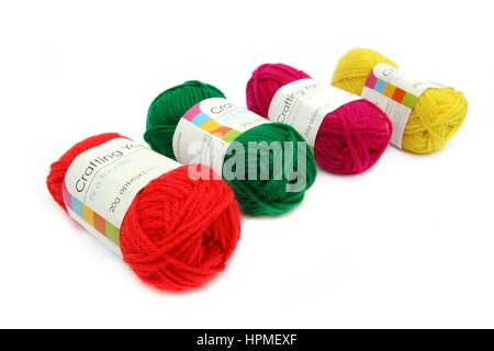 Camberley, UK - Feb 22nd 2017: Four balls of colorful red, green, yellow and pink wool or yarn on a white background Stock Photo