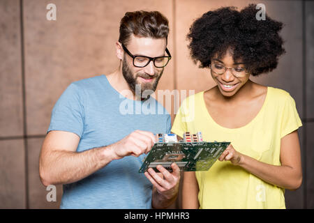 Programmers with computer motherboard Stock Photo