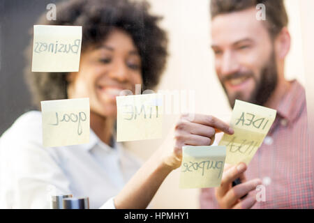 Coworkers working with stickers on the door Stock Photo