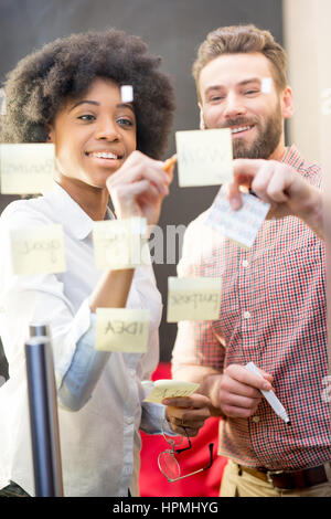 Coworkers working with stickers on the door Stock Photo