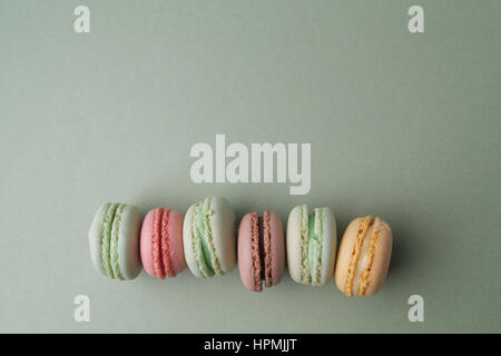 Vintage pastel colored French macarons on green Stock Photo