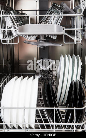 Clean dishes in a modern dishwasher machine Stock Photo