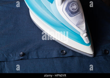 White modern iron on dark blue shirt Stock Photo