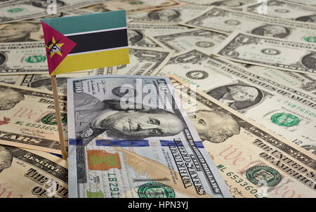 Flag of Mozambique sticking in a variety of american banknotes.(series) Stock Photo