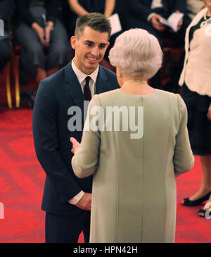 Gold medal winning Olympic gymnast Max Whitlock receives his Member of the Order of British Empire (MBE) medal from Queen Elizabeth II during an Investiture ceremony at Buckingham Palace, London. Stock Photo