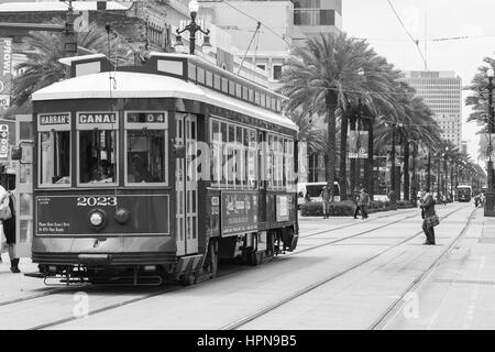 NEW ORLEANS, USA - MAY 14, 2015: Streetcar on Canal Street, in the back another streetcar approaching and people crossing the street. Stock Photo