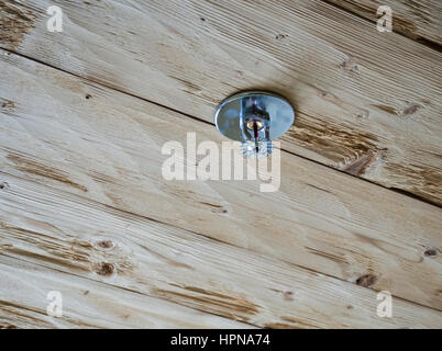 Sprinkler system installed on a flammable wooden ceiling of a wooden house / cabin Stock Photo