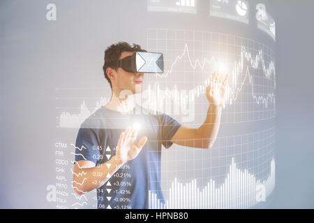 Person wearing virtual reality (VR) headset or head-mounted display (HMD) glasses to interact with financial dashboard with stock market key performan Stock Photo