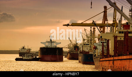 vessel berthing to port with tug boat pushing the vessel to along side at jetty Stock Photo