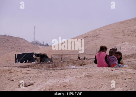 Group of young Bedouin girls of the Jahalin tribe community sitting outside their family tent in the Judaean or Judean desert of the West Bank Israel. Stock Photo