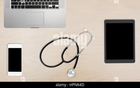 Clean and tidy wooden desk with equipment ready for medical doctor using latest technology instead of paper records Stock Photo