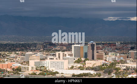 Downtown area of Tucson in Arizona with the sun lighting the buildings while storm clouds gather over distant mountain range Stock Photo