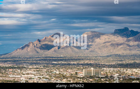 Downtown area of Tucson in Arizona with the sun lighting the buildings while storm clouds gather over distant Santa Catalina mountain range Stock Photo