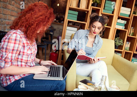 Two female students prepare exam together Stock Photo