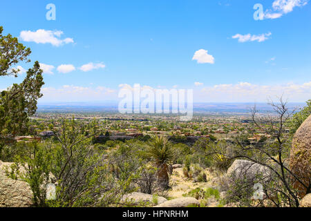 Distant view of Albuquerque, USA, from the base station of the Sandia Peak Tramway, in the foreground rocks and scrubs and other plants. Stock Photo
