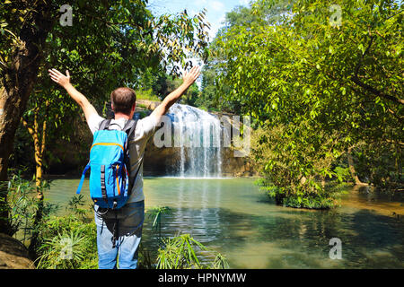 Man with backpack looking at scenic waterfall in Vietnam Stock Photo