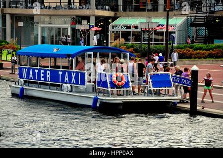 Baltimore, Maryland - July 22, 2013:  Passengers disembark a water taxi boat at the Inner Harbor stop Stock Photo