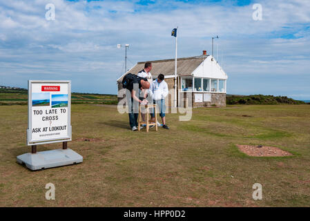 Visitors signing to show they have crossed the causeway to Worms Head. Coast Guard look out station at Rhossili,Gower Peninsula, Swansea, Wales, UK. Stock Photo