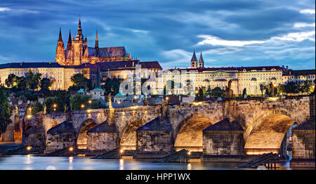 A night time view of the Charles Bridge over the River Vltava in Prague, Czech Republic. Prague Castle and St Vitus Cathedral are in the background. Stock Photo