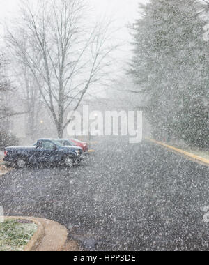 Heavy snowfall blizzard in neighborhood with road and houses Stock Photo