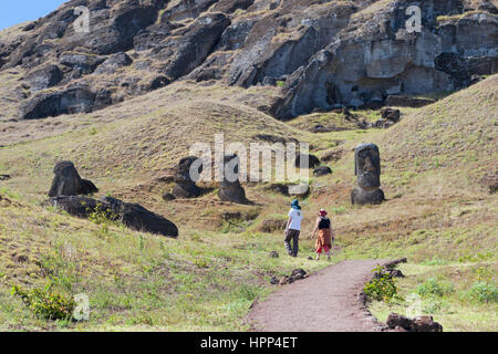 Two people walking along path through Rano Raraku moai quarry on Easter Island Stock Photo