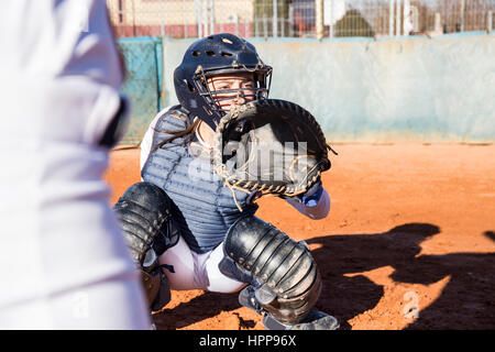 Female catcher ready to catch the ball during a baseball game Stock Photo