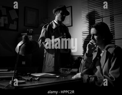 Detective interviewing a young sad woman in his office, film noir scene. Stock Photo