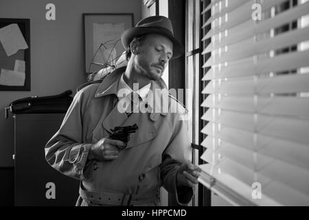 Attractive spy agent peeking from an office window, film noir. Stock Photo