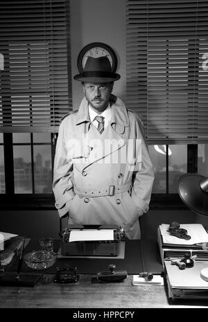 Attractive detective standing next to his desk, 1950s style office. Stock Photo