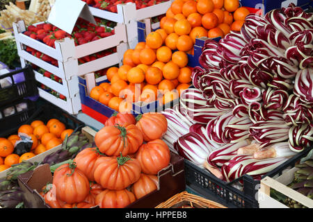 stall of greengrocer with tomatoes red chicory called radicchio oranges and lots of fresh fruits and season vegetables for sale Stock Photo