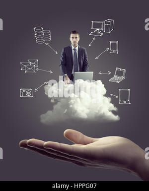 Businessman with laptop on cloud with hand drawn technology icons and hand. Stock Photo