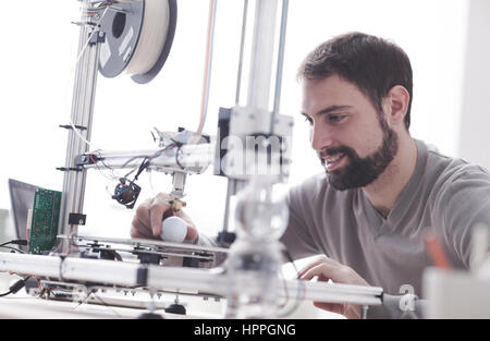 Young designer engineer using a 3D printer in the laboratory and studying a product prototype, technology and innovation concept Stock Photo