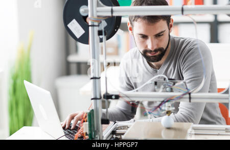 Young designer engineer using a 3D printer in the laboratory and studying a product prototype, technology and innovation concept Stock Photo