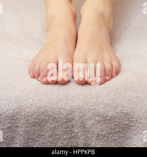 Beautiful female feet on a towel after pedicure treatment at spa. Stock Photo