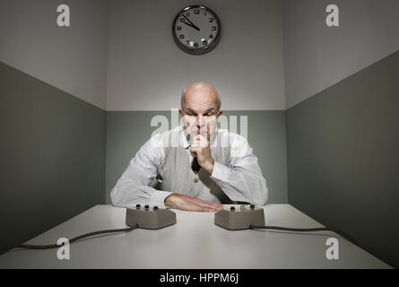 Confused office worker at his desk with intercoms. Stock Photo