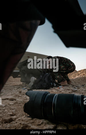 Harry Martinez and two yazidi fighters take cover behind a pickup truck after coming under bombardment from Islamit State Mortars Stock Photo