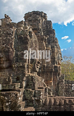 A close up view of some of the many smiling stone faces of Prasat Bayon - the last state temple to be built at the Angkor complex on a sunny day. Stock Photo