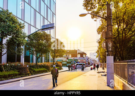 SHANGHAI, CHINA - MARCH 11: Side road of Pudong financial district area in Shanghai. The road shows people and local chinese shops in the background o Stock Photo