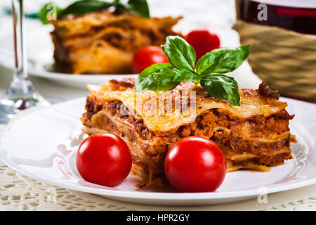 Piece of tasty hot lasagna with red wine. Selective focus Stock Photo