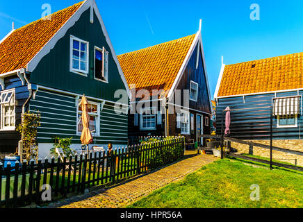 Typical traditional houses with green wall and red tiled roof in the historic fishing village of Marken in the Netherlands Stock Photo